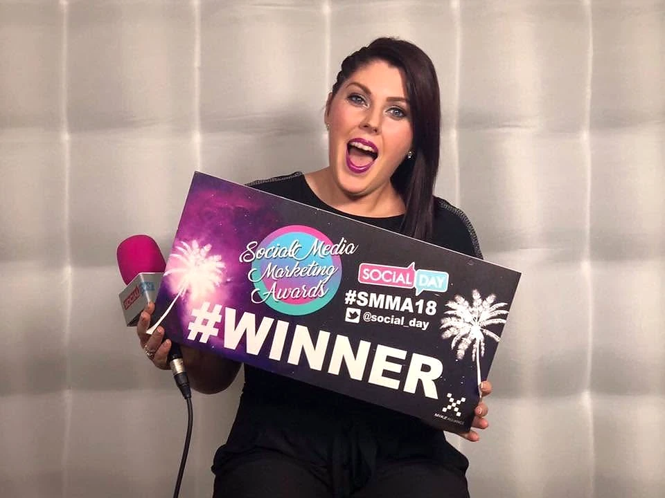 Sarah Jane Vincent holding a Social Media Marketing Awards winner sign